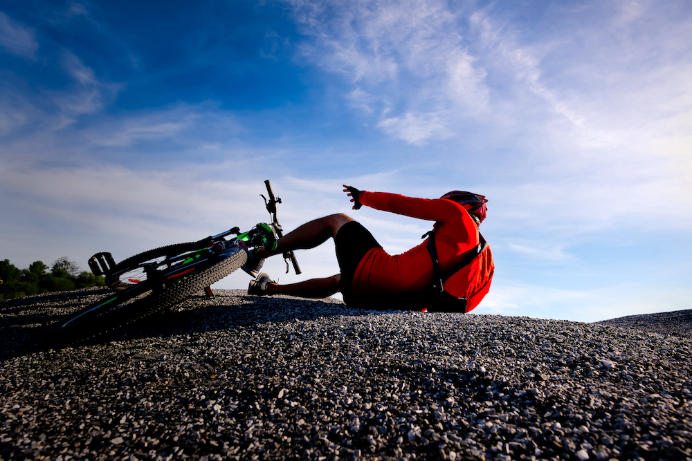 Cyclist riding mountain bike on the rocky trail at sunset,crashing on mountain bike.