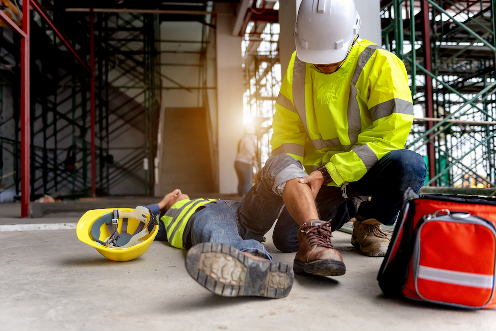 First aid support accident at work of construction worker at site. Builder accident falls scaffolding on floor, Safety team helps employee accident.